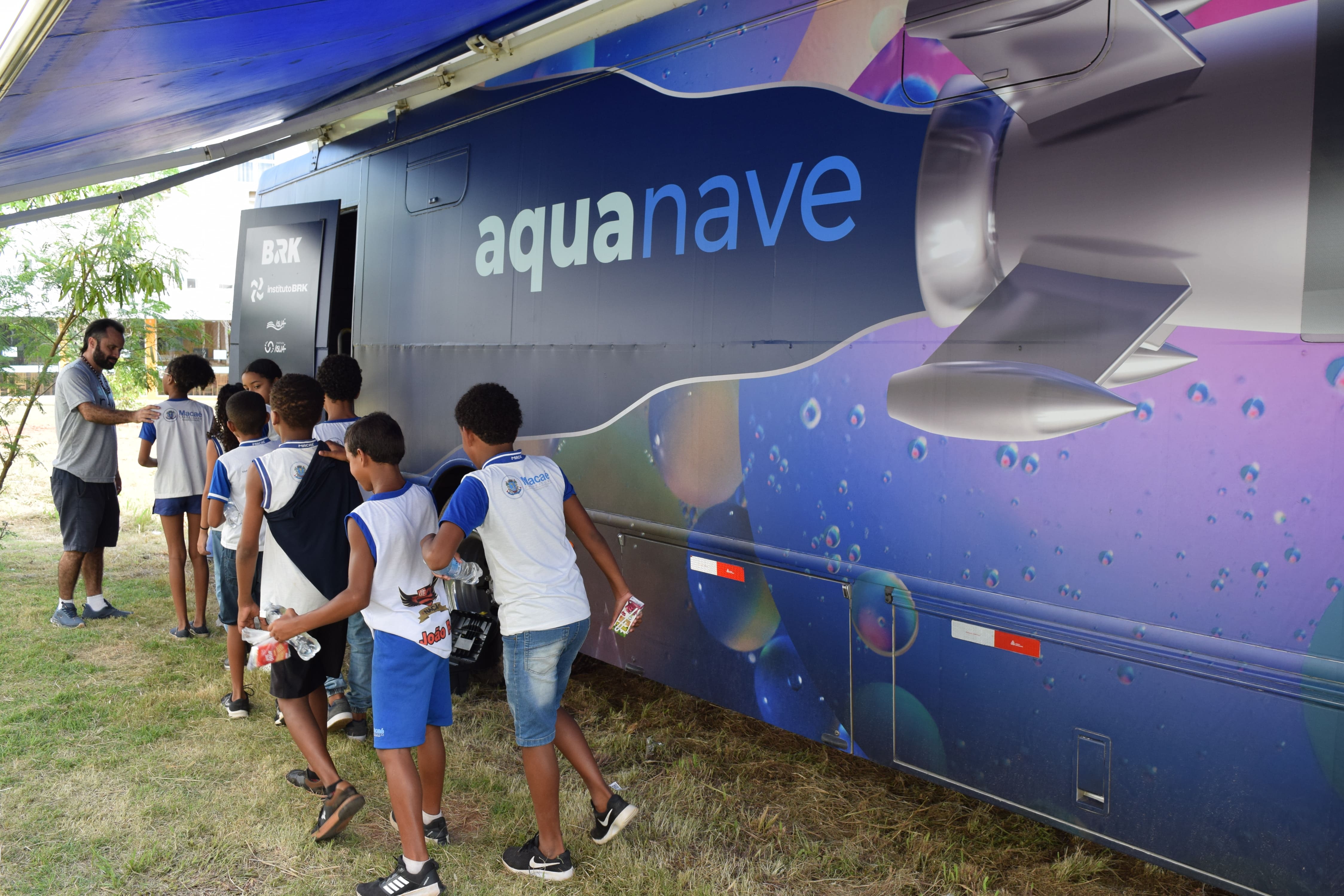 Dentro do veículo e com óculos especiais de realidade virtual, as crianças sobrevoam parte da bacia hidrográfica do município